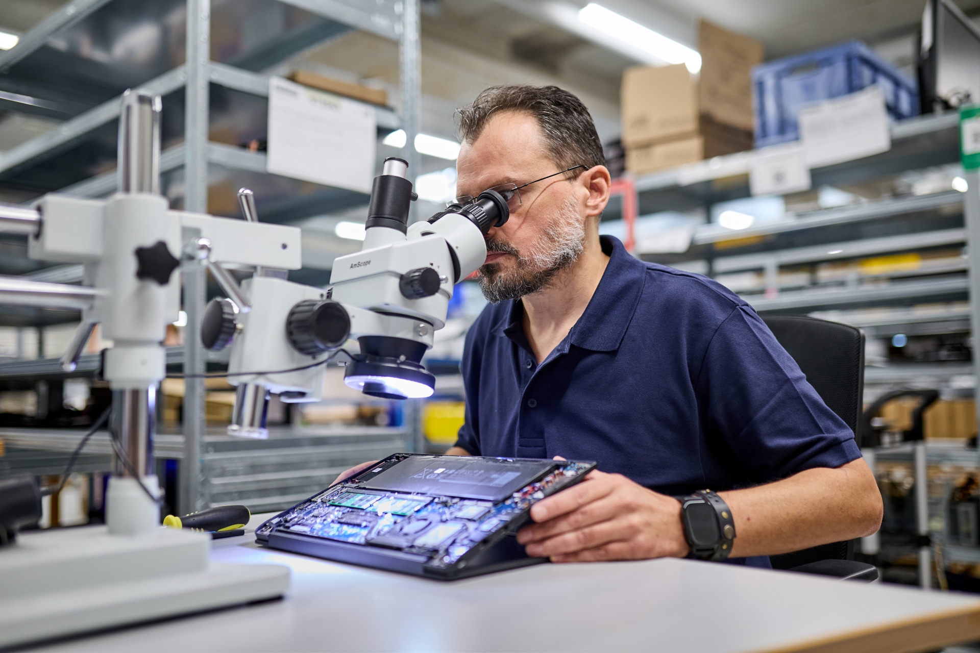 Das Bild zeigt einen afb-Mitarbeiter, der ein Notebook prüft